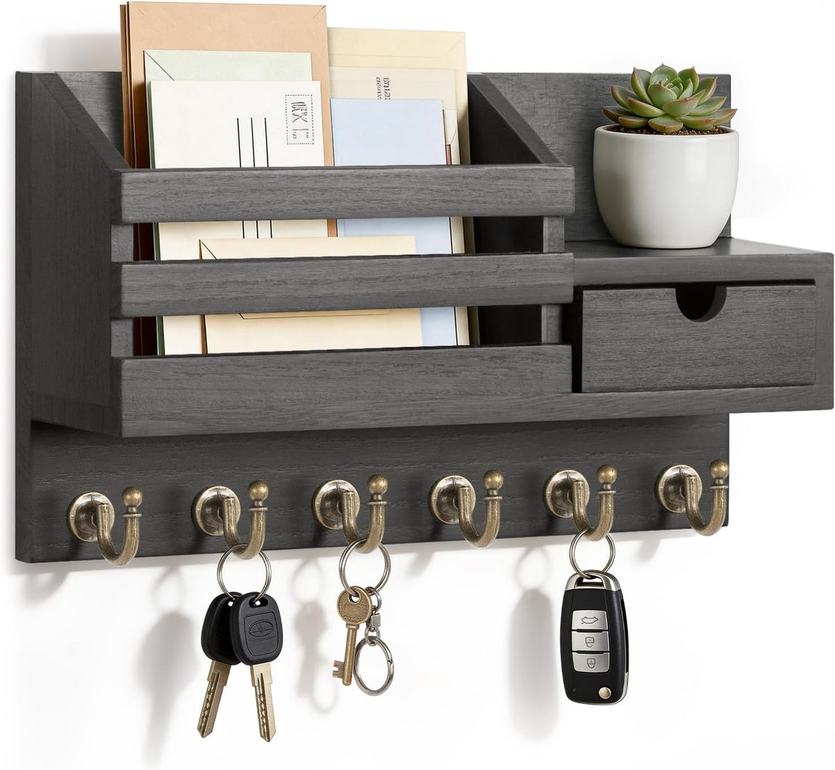 Close-up of dark gray wall organizer with envelopes in the mail slot, a small potted succulent on top, a closed drawer and