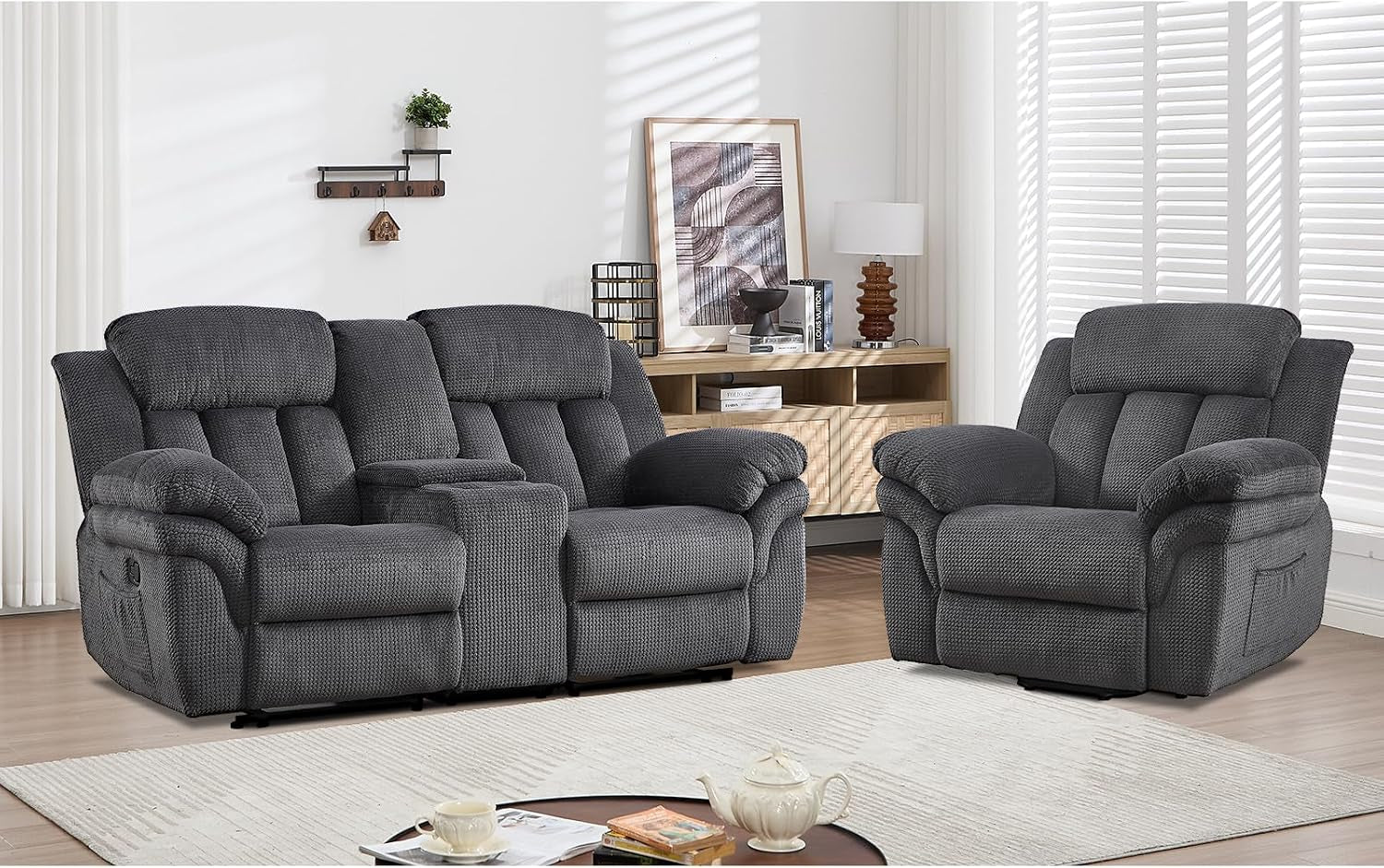 Wide shot of a reclining sofa paired with a matching single recliner in a bright, styled living room.