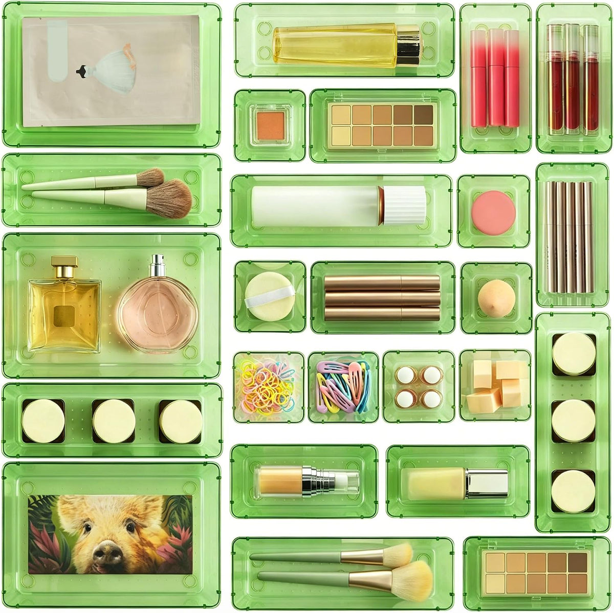 Top-down view of translucent green trays arranged with makeup, brushes and small accessories inside