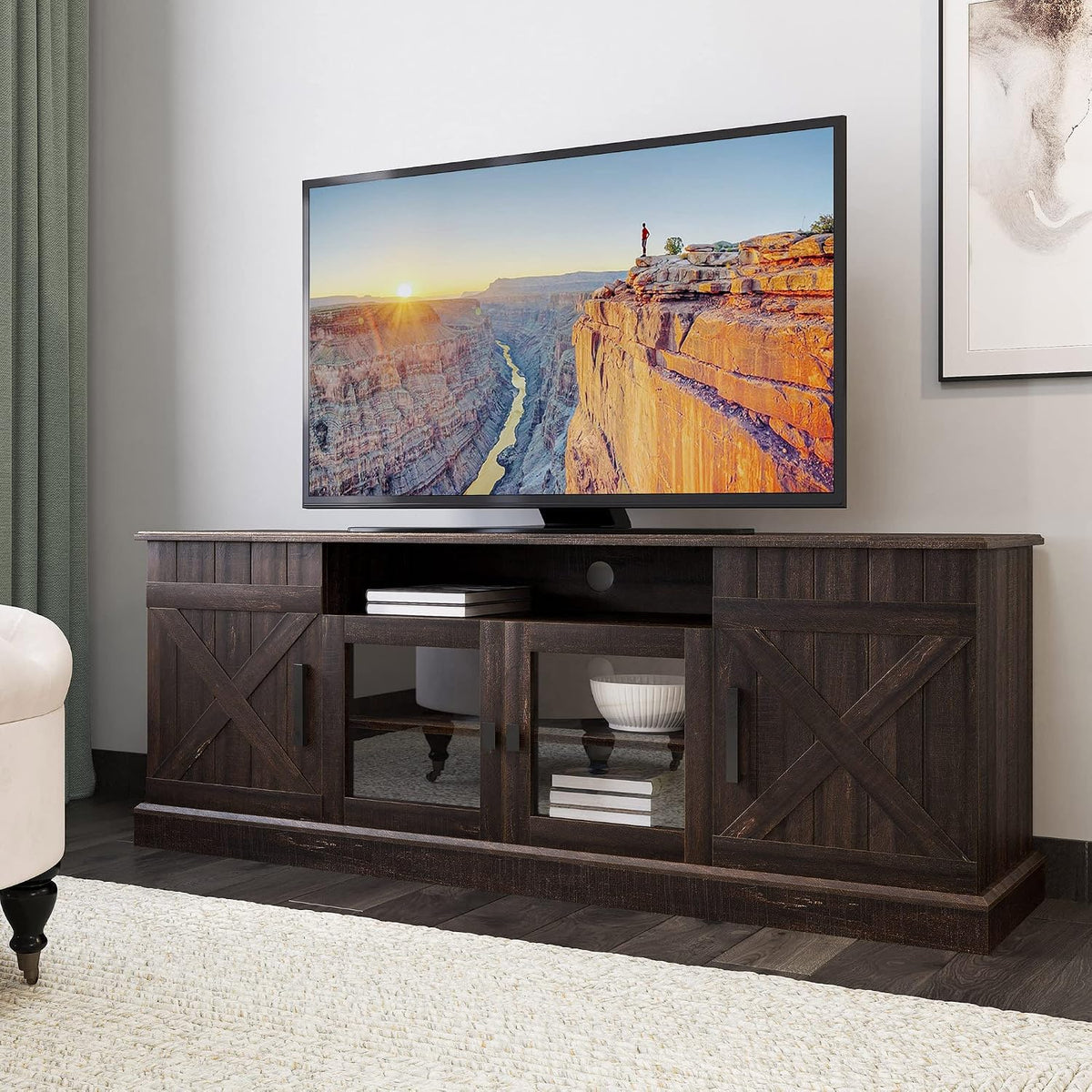 Dark brown ashland-pine TV stand below a large TV, green curtain at left and framed art at right.
