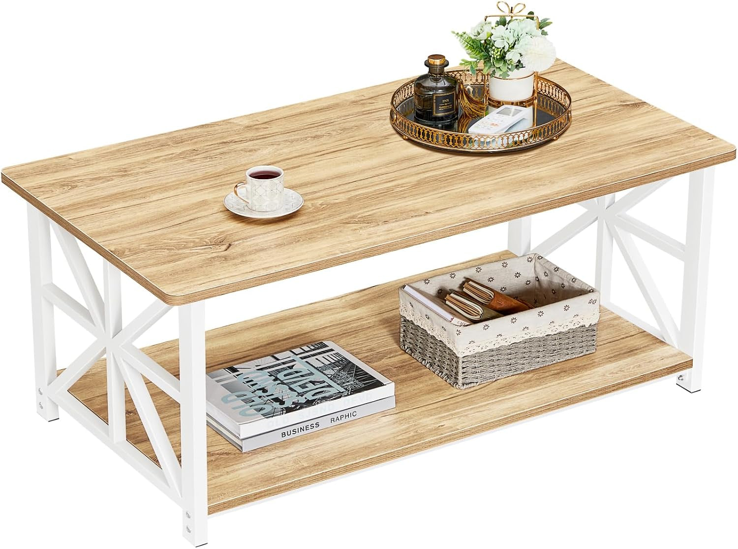 Rectangular light wood top coffee table with white X-frame sides and lower shelf, decorated with a cup and tray.