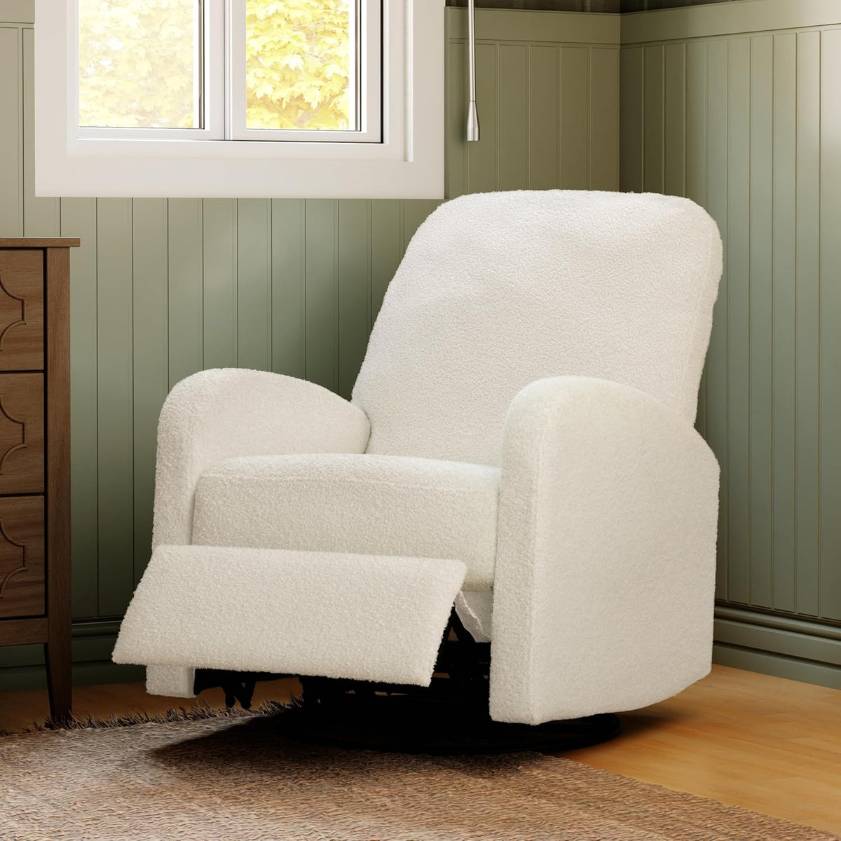 Cream boucle swivel recliner in a corner with footrest extended on a rug beneath a window