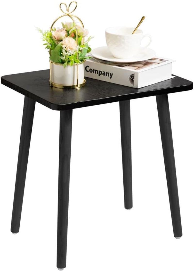 Small black rectangular side table with matching black tapered legs, styled with a teacup and small floral arrangement.