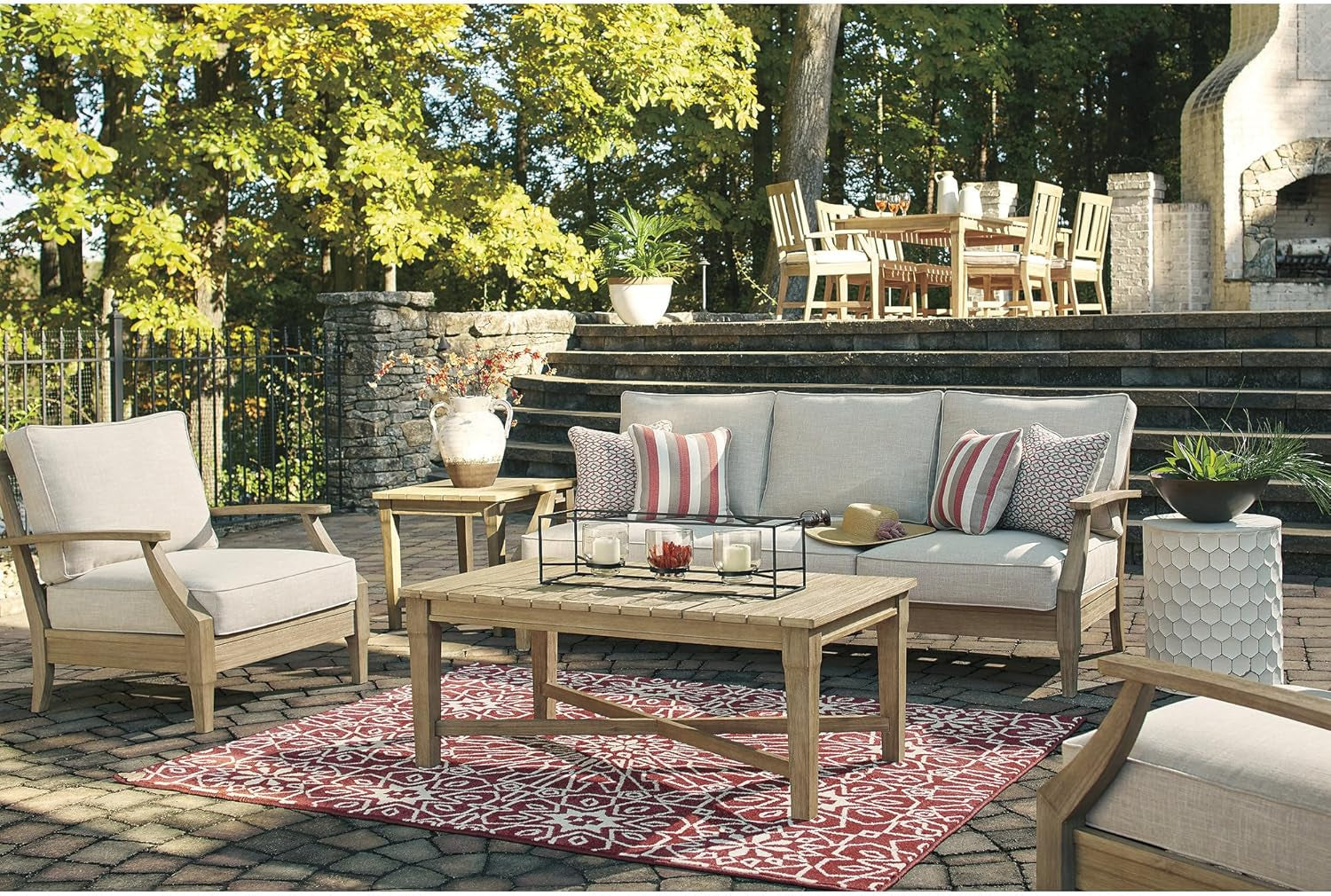 Patio scene with the three-seat sofa, matching armchair and coffee table arranged on a brick terrace