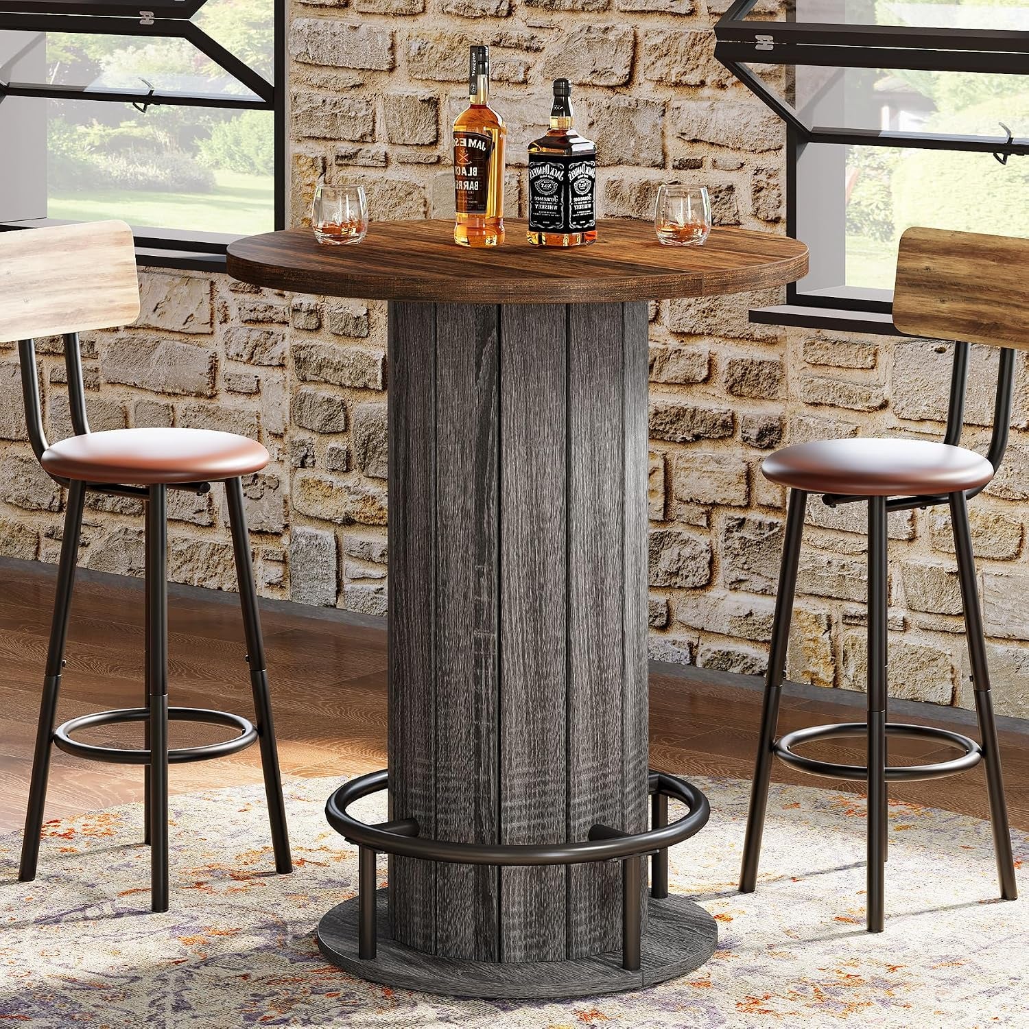 Round pub table near a window and brick wall with bottles and glasses on the wood-grain tabletop