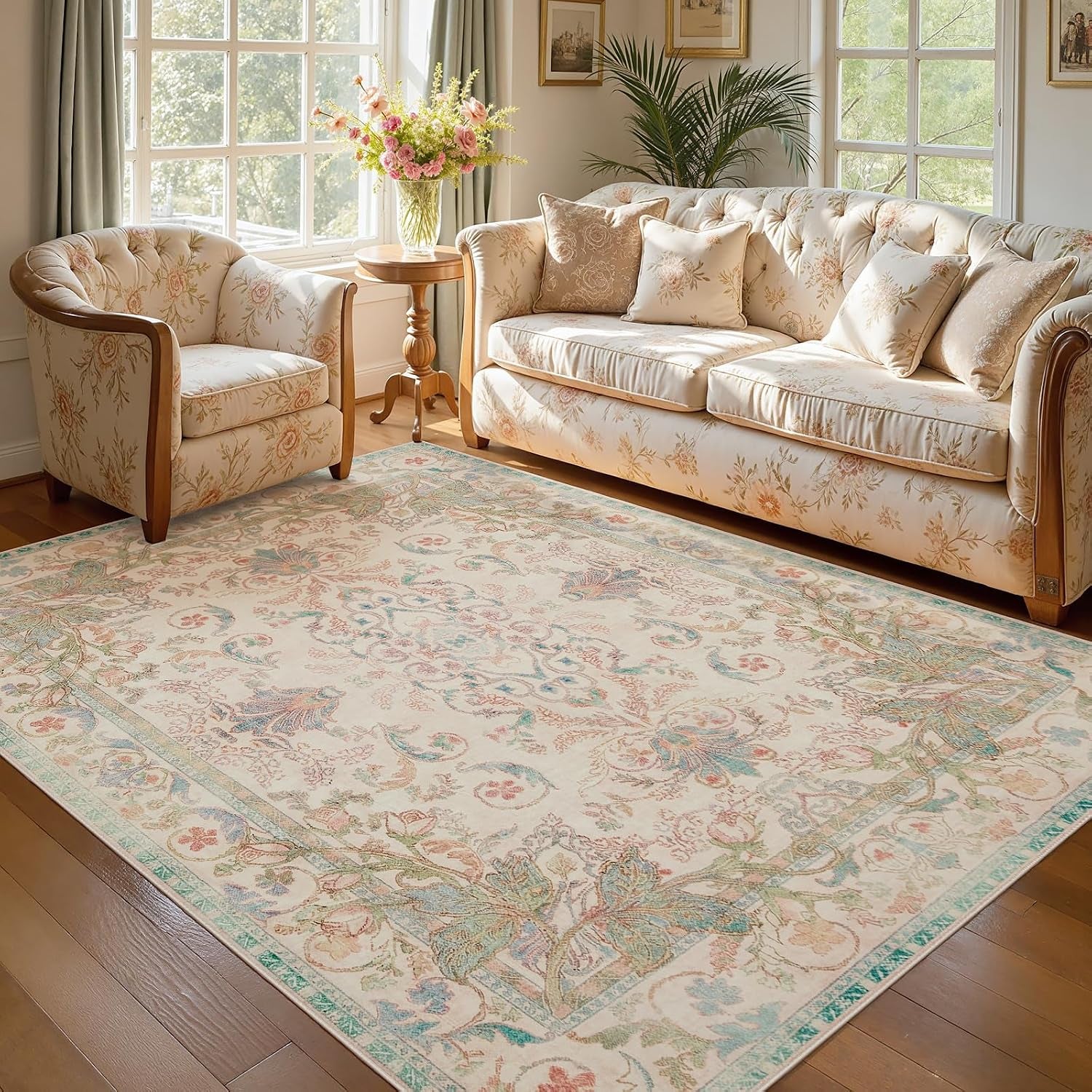 Front-angle living area with a tufted floral sofa and matching armchair placed over a medallion-pattern rug.