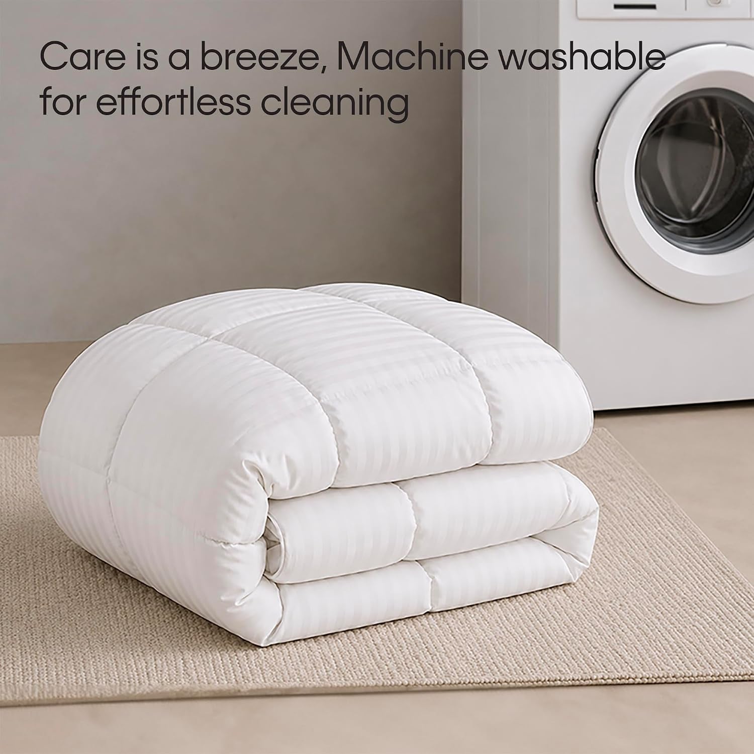 Folded white comforter on a beige rug beside a front-load washing machine
