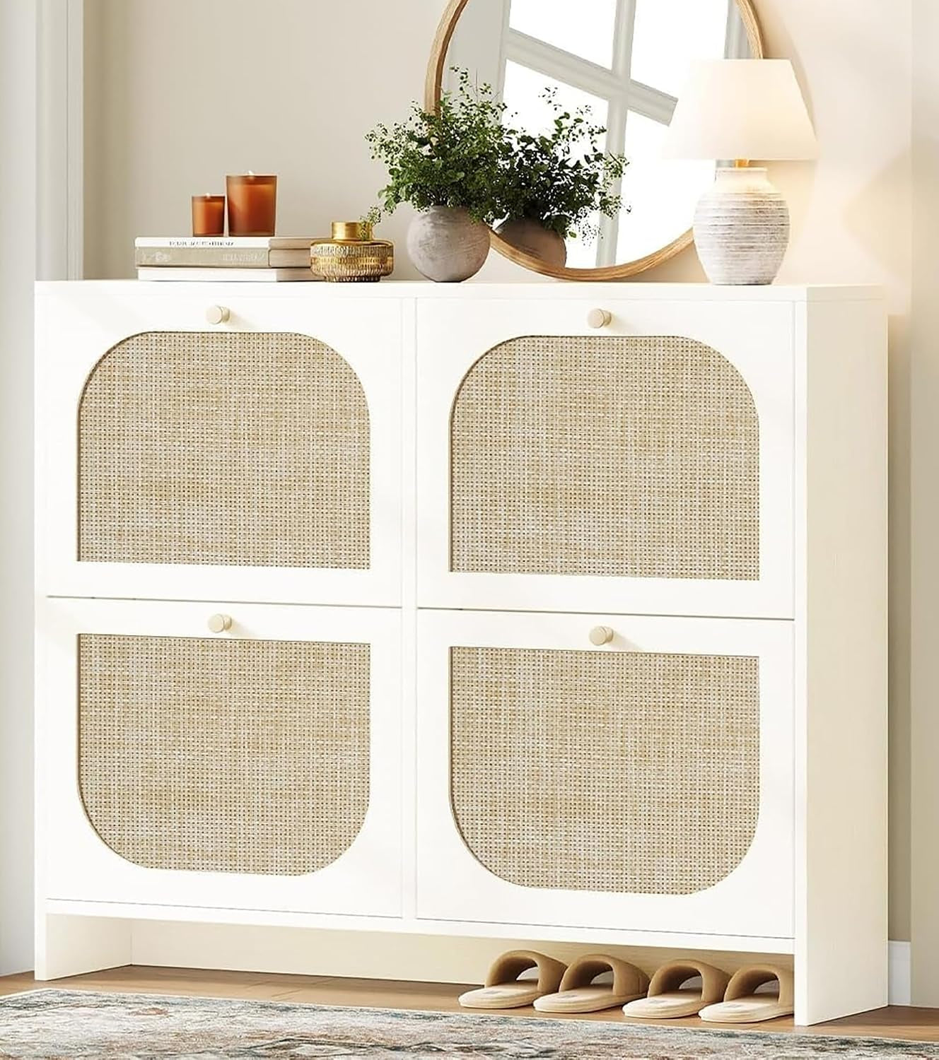 Wide white shoe cabinet with four woven cane panels and decorative items on top.