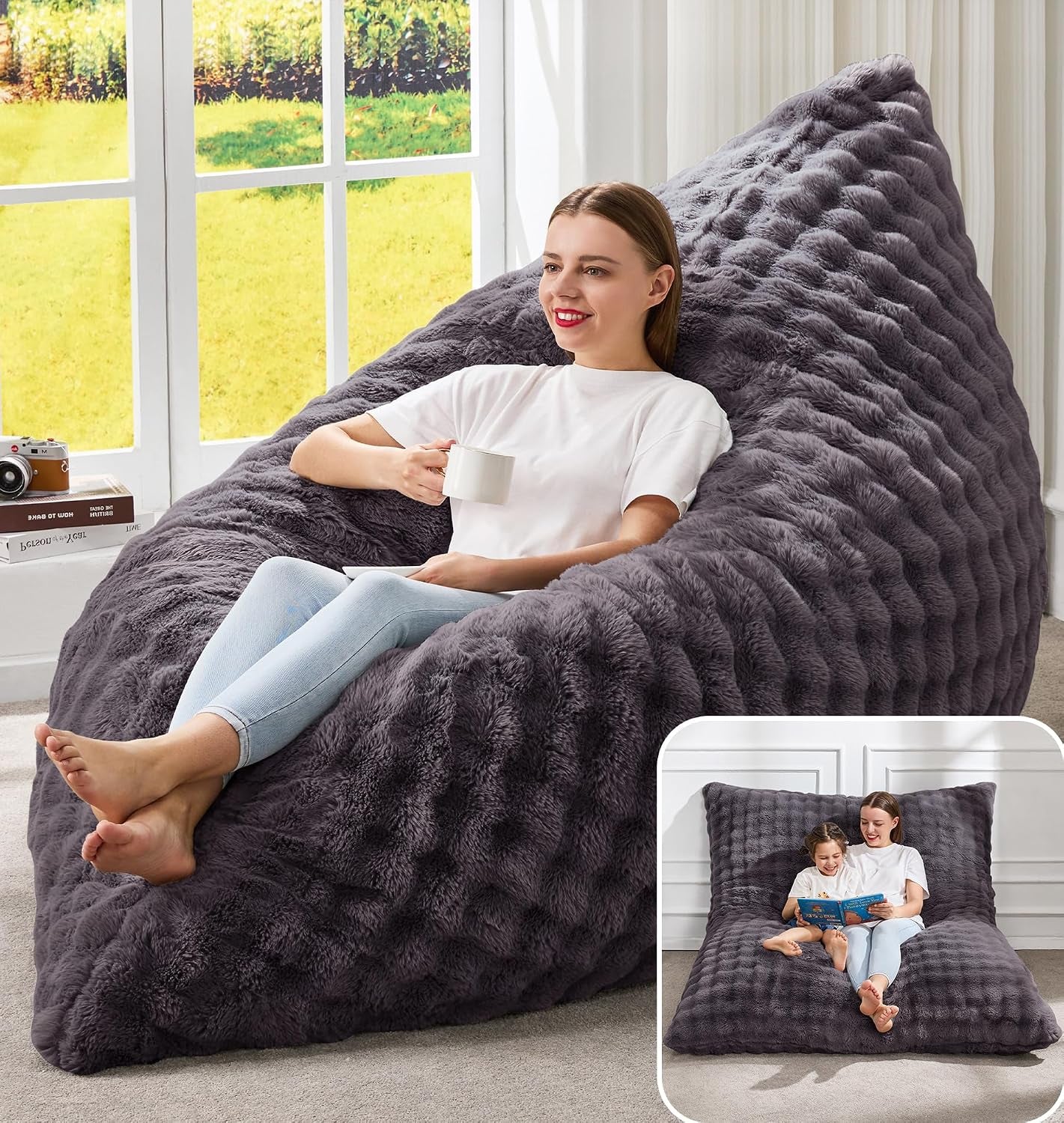 Smiling woman seated on a plush dark gray bag chair, holding a mug with a small inset of the flat sofa configuration.