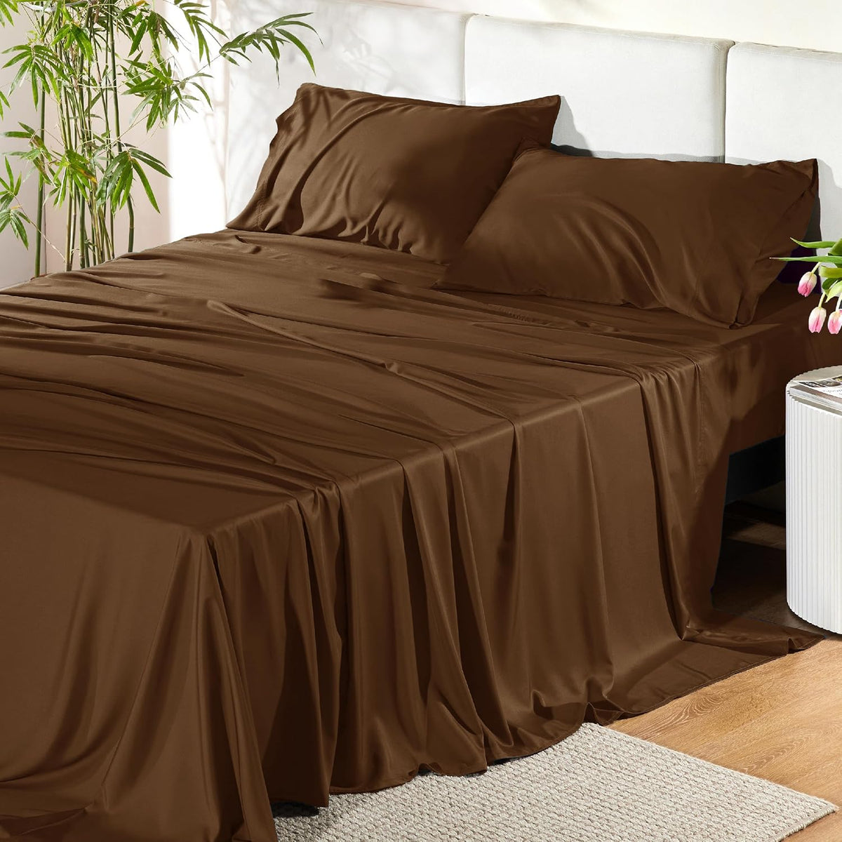 Queen bed dressed in dark brown sheets and two matching pillowcases