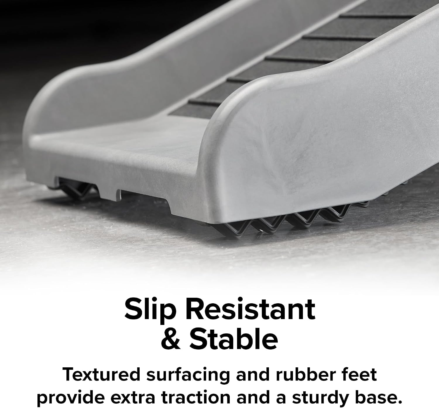 Close-up of the ramp's lower end showing rubber anti-slip feet beneath the molded resin edge.