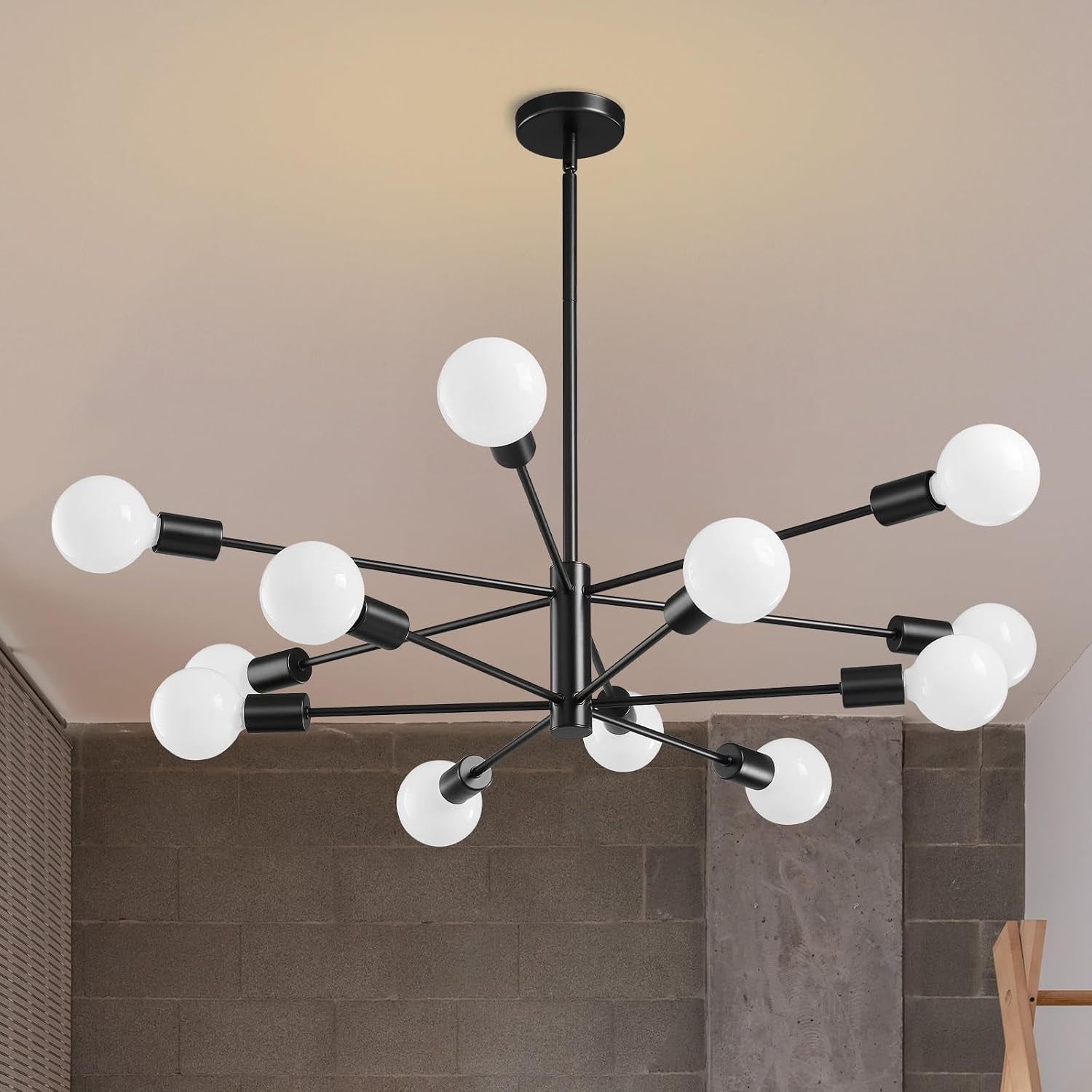 Large black sputnik chandelier with twelve white globes viewed from below against a textured wall.