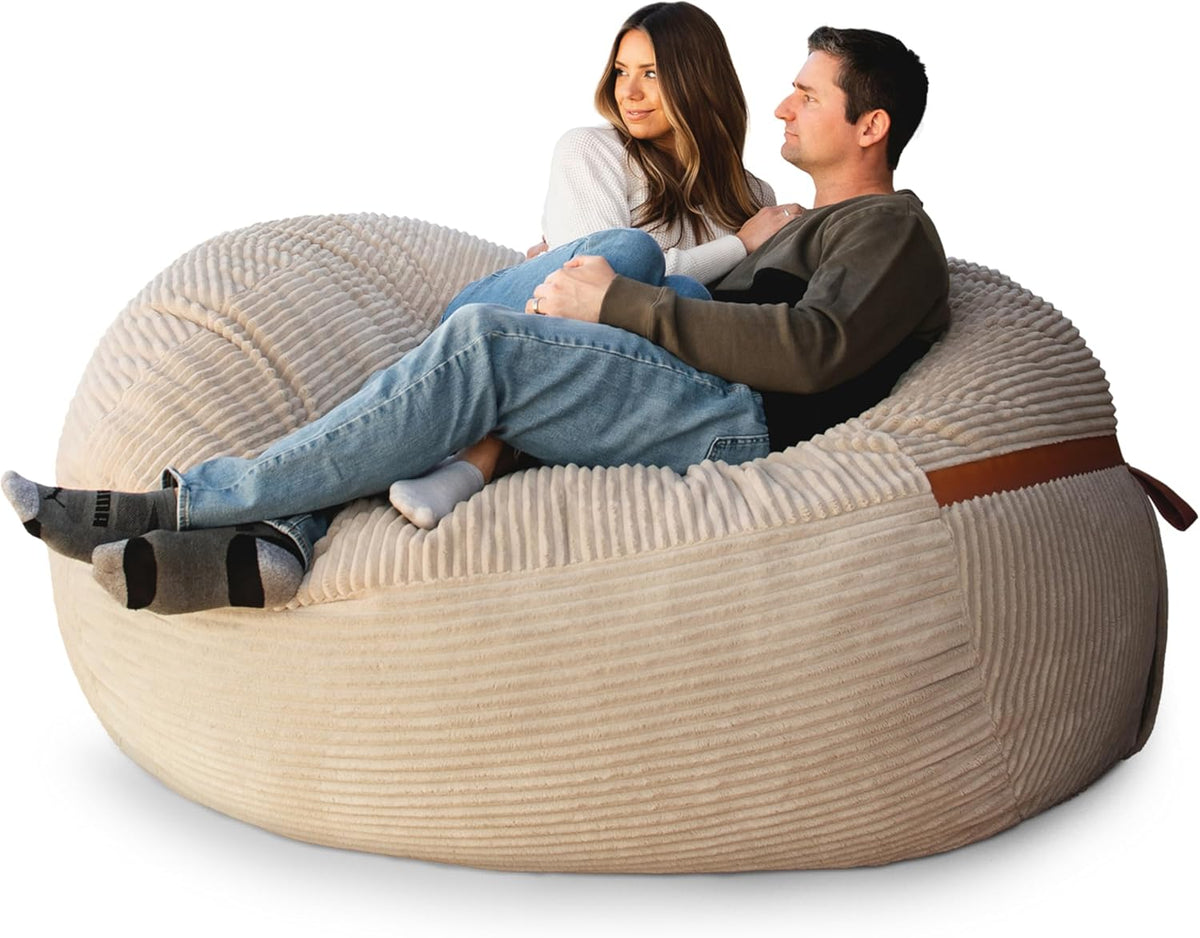 Beige corded-plush oversized lounger with two people seated, front view on a white background