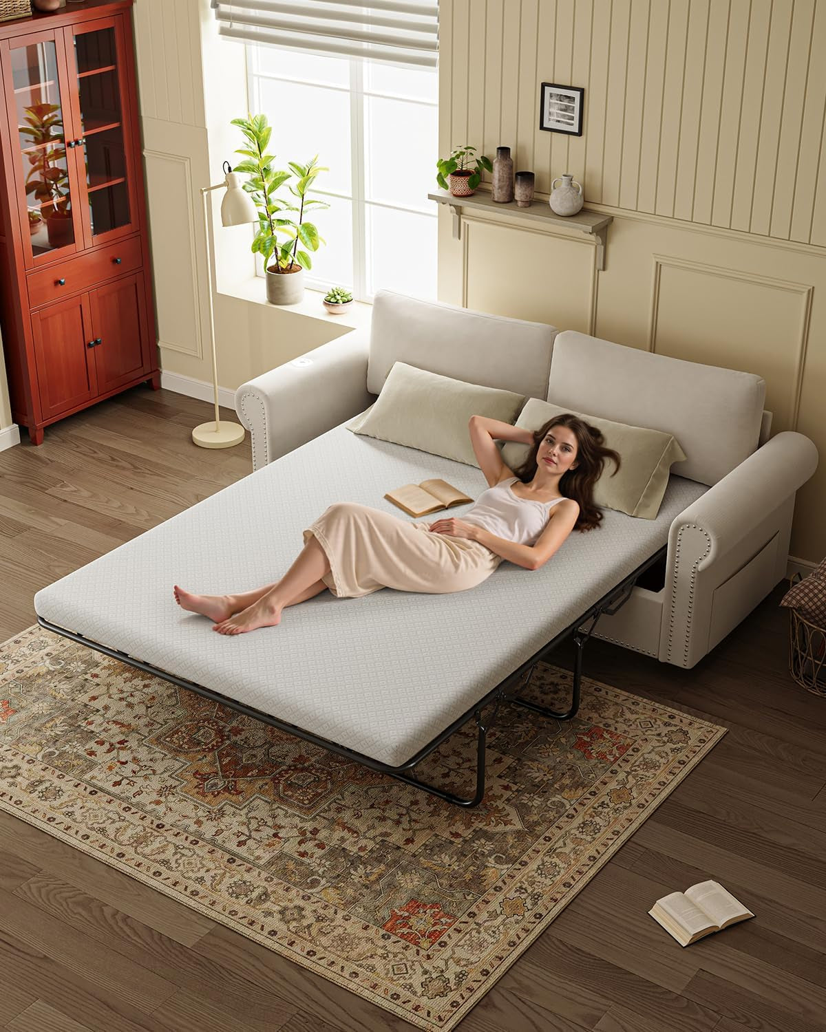 Beige sofa bed with queen mattress pulled out and person reclining to show the sleeping surface