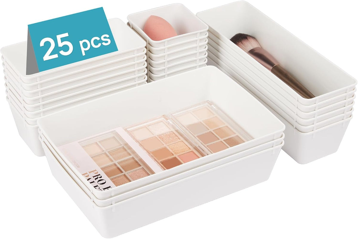 Low-angle view of stacked white plastic trays holding makeup palettes, a blending sponge and a makeup brush.