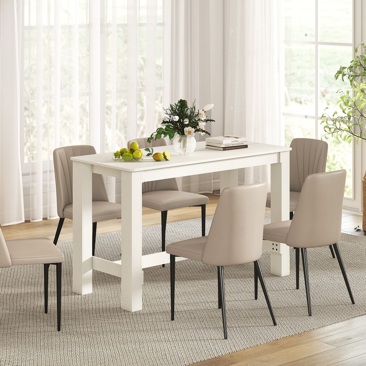 White rectangular dining table surrounded by upholstered chairs in a bright dining room