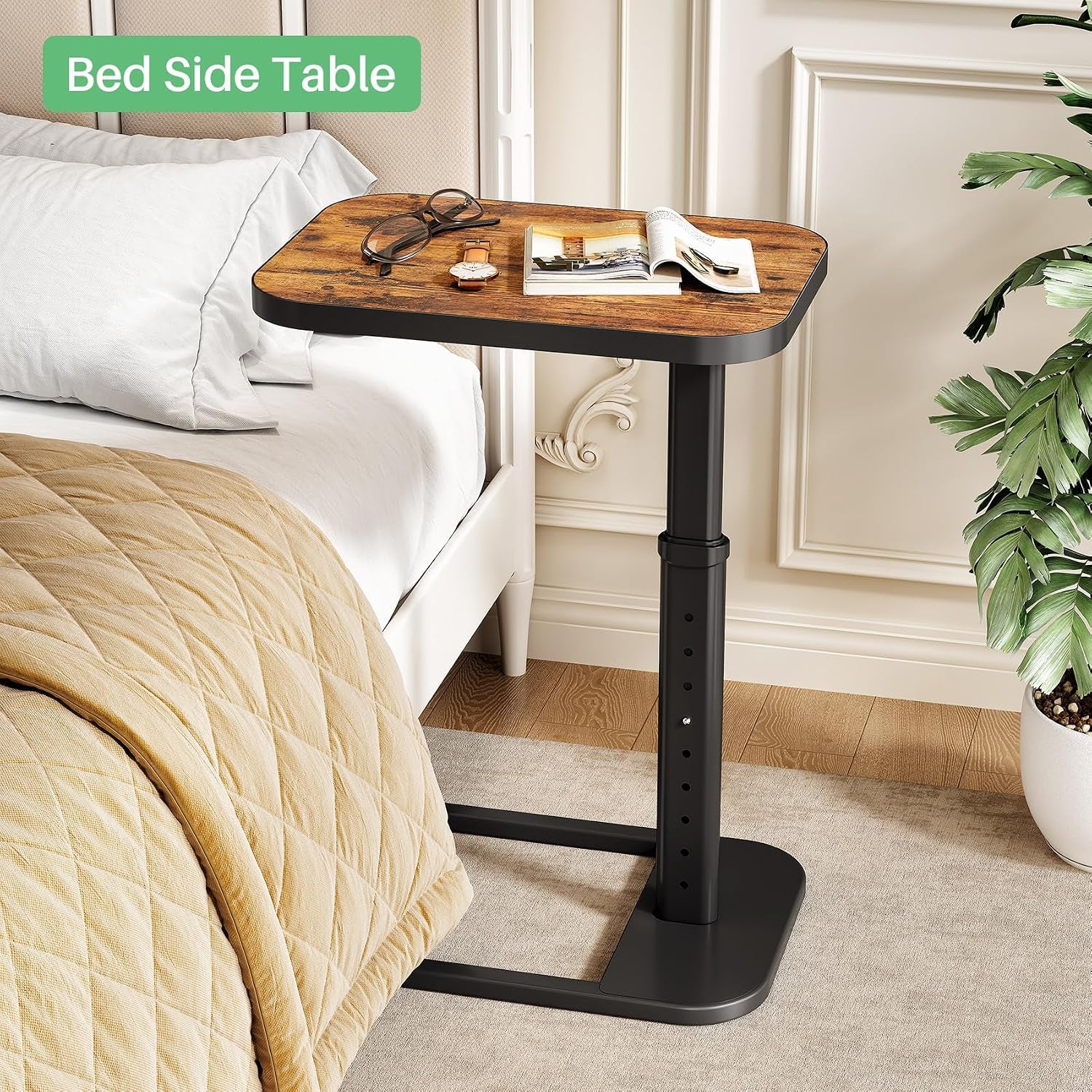Brown wood-top C-shaped side table next to a bed on a carpeted floor