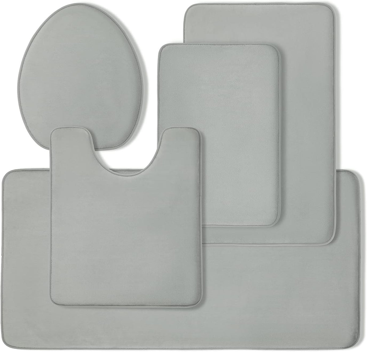 Top-down flat lay of four light gray memory-foam bath rugs arranged together on white background