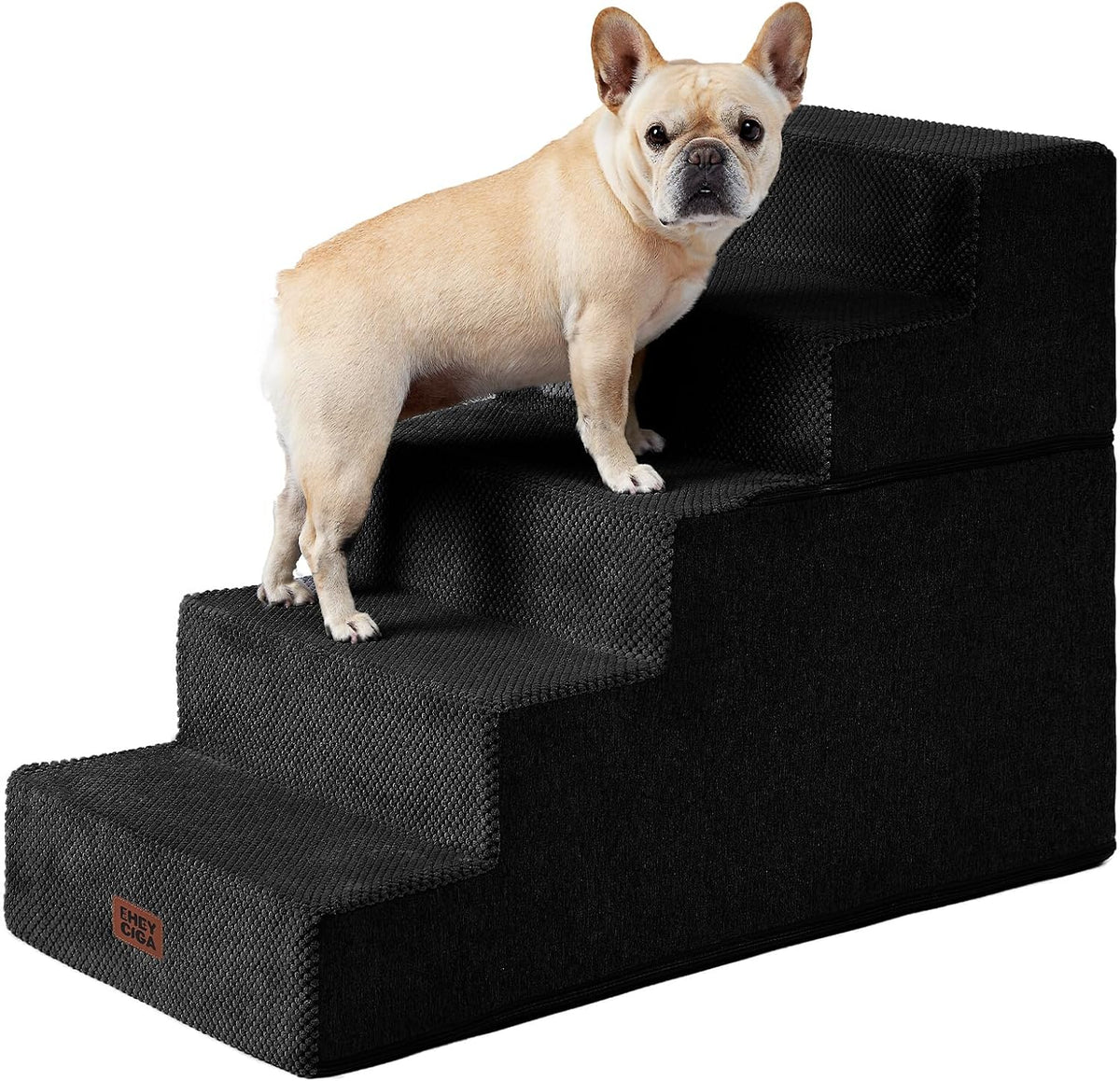 Light tan French bulldog standing on black four-step foam stairs against white background