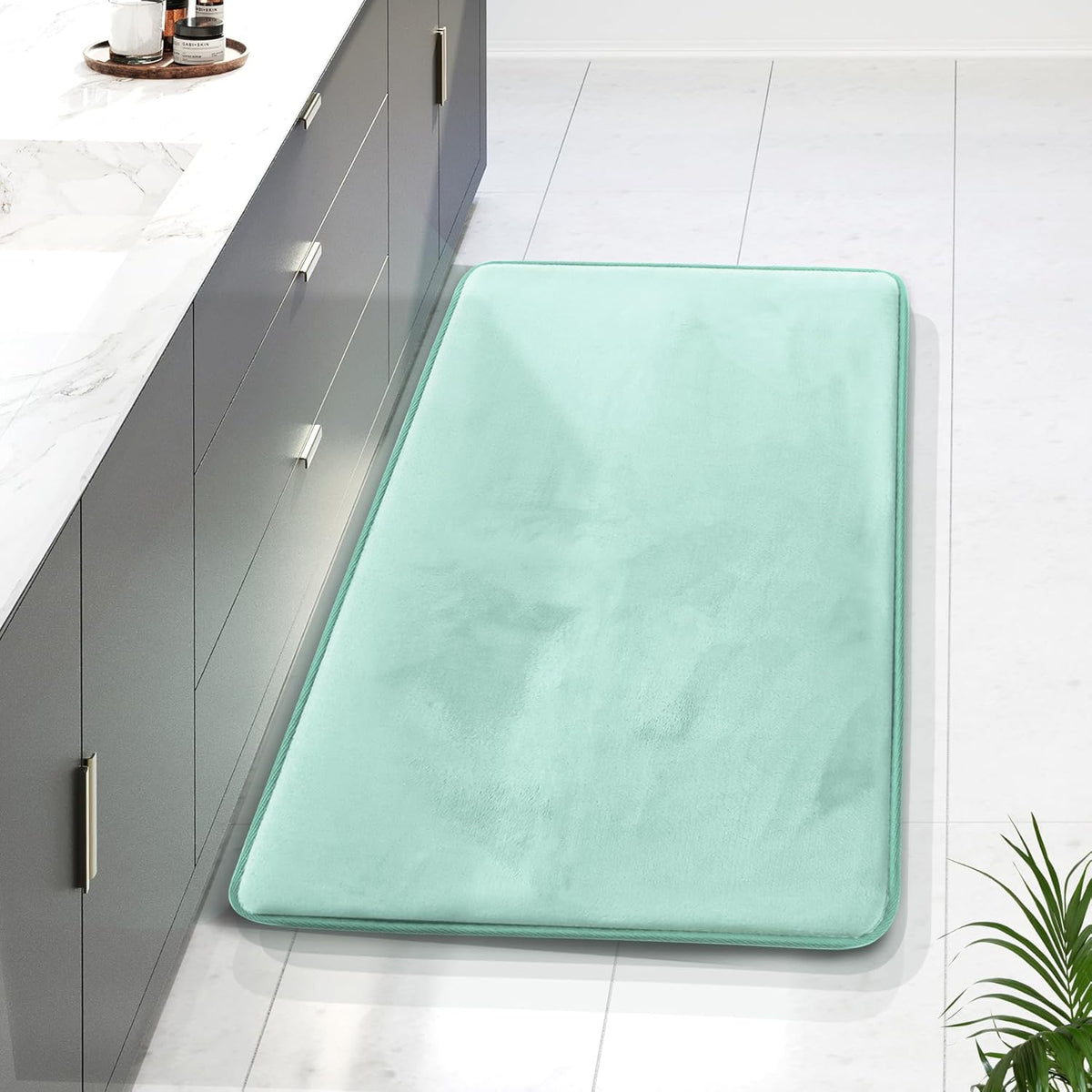 Mint green long runner rug beside a dark gray vanity on a bright tiled bathroom floor.