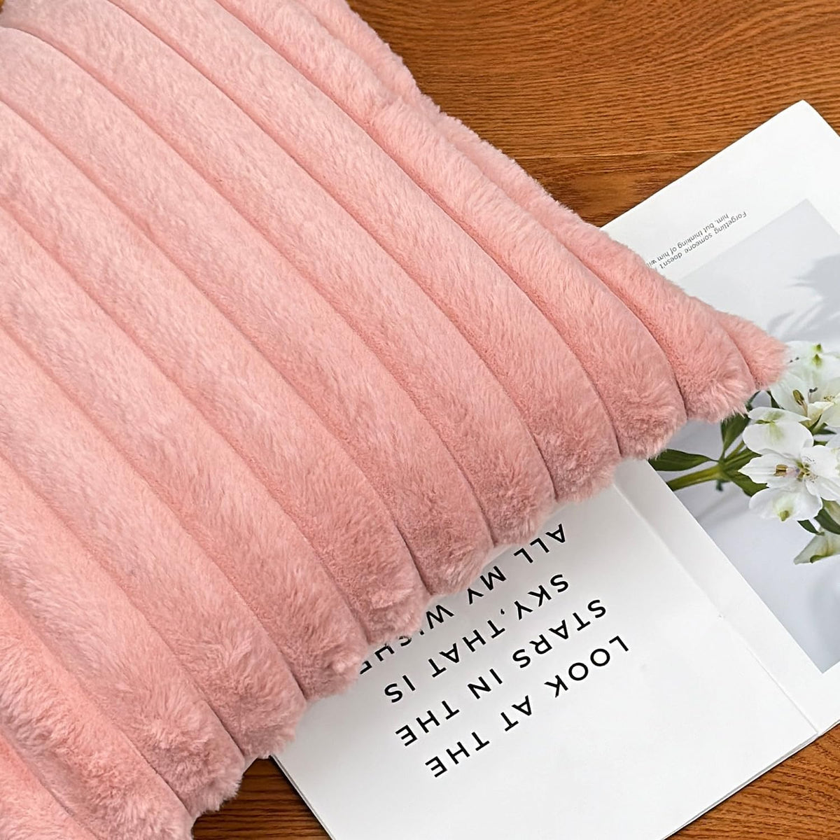 Close-up of a soft pink ribbed faux-fur pillow showing plush texture and ridged stitching