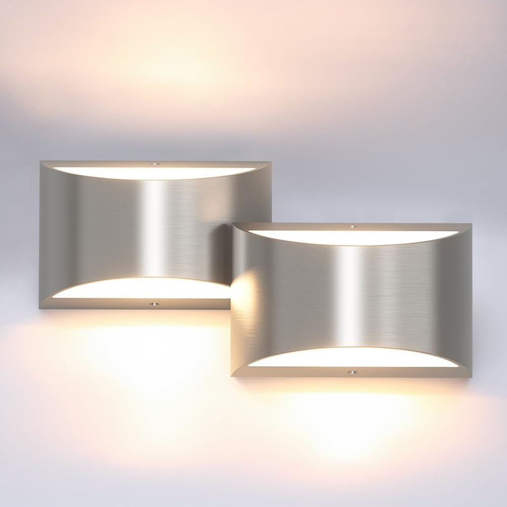 Two rectangular brushed-silver wall sconces side-by-side, casting warm light upward and downward.