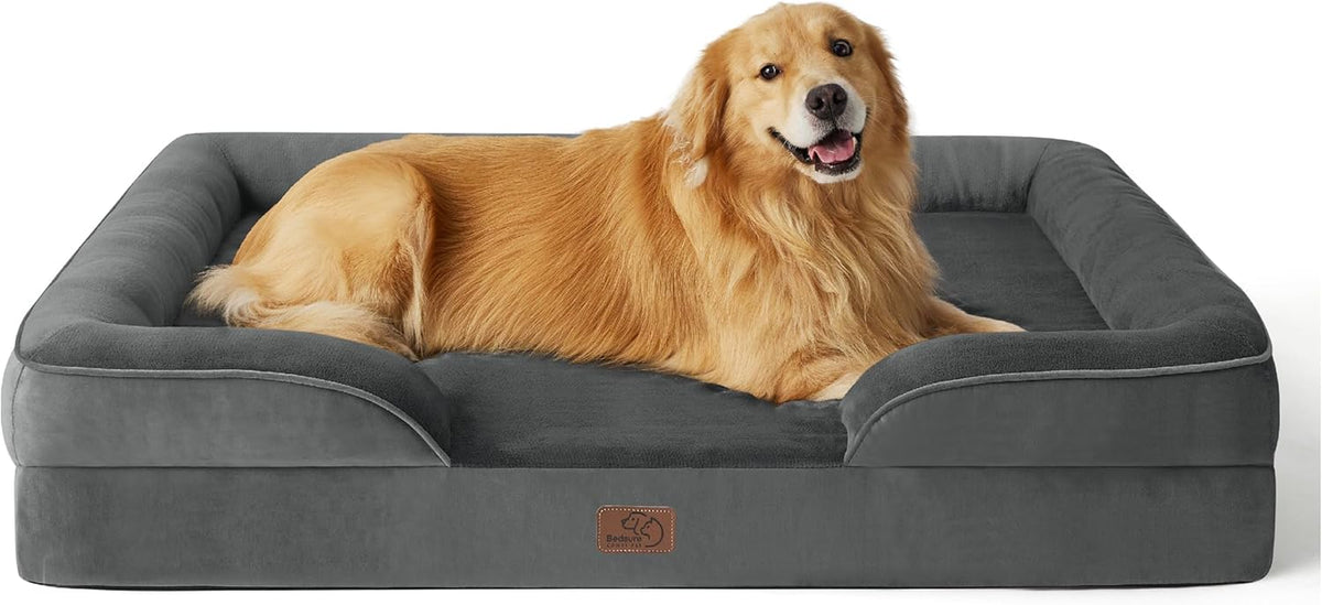Charcoal-gray bolster bed with matching cushion; a golden retriever lying across the sleeping area, smiling.