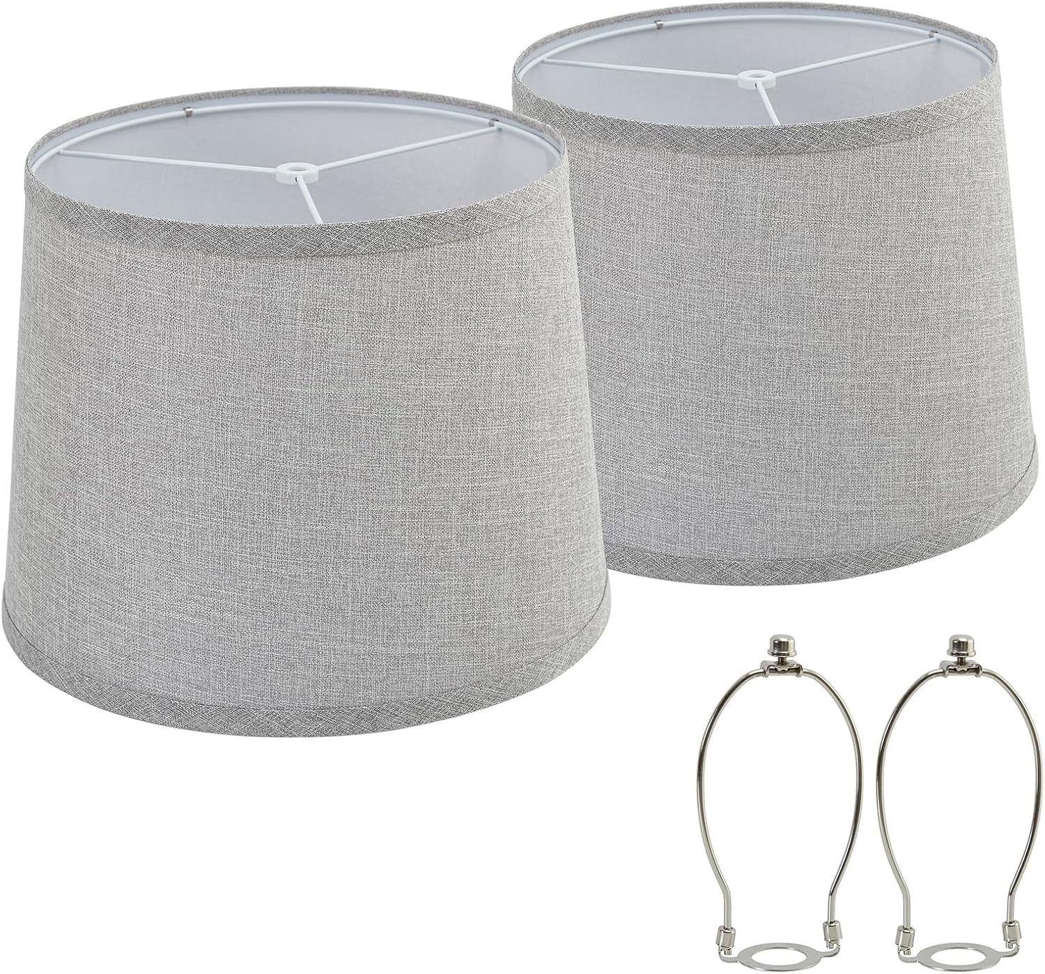Two light-gray tapered lampshades shown from a slight angle with two silver harp fittings below.