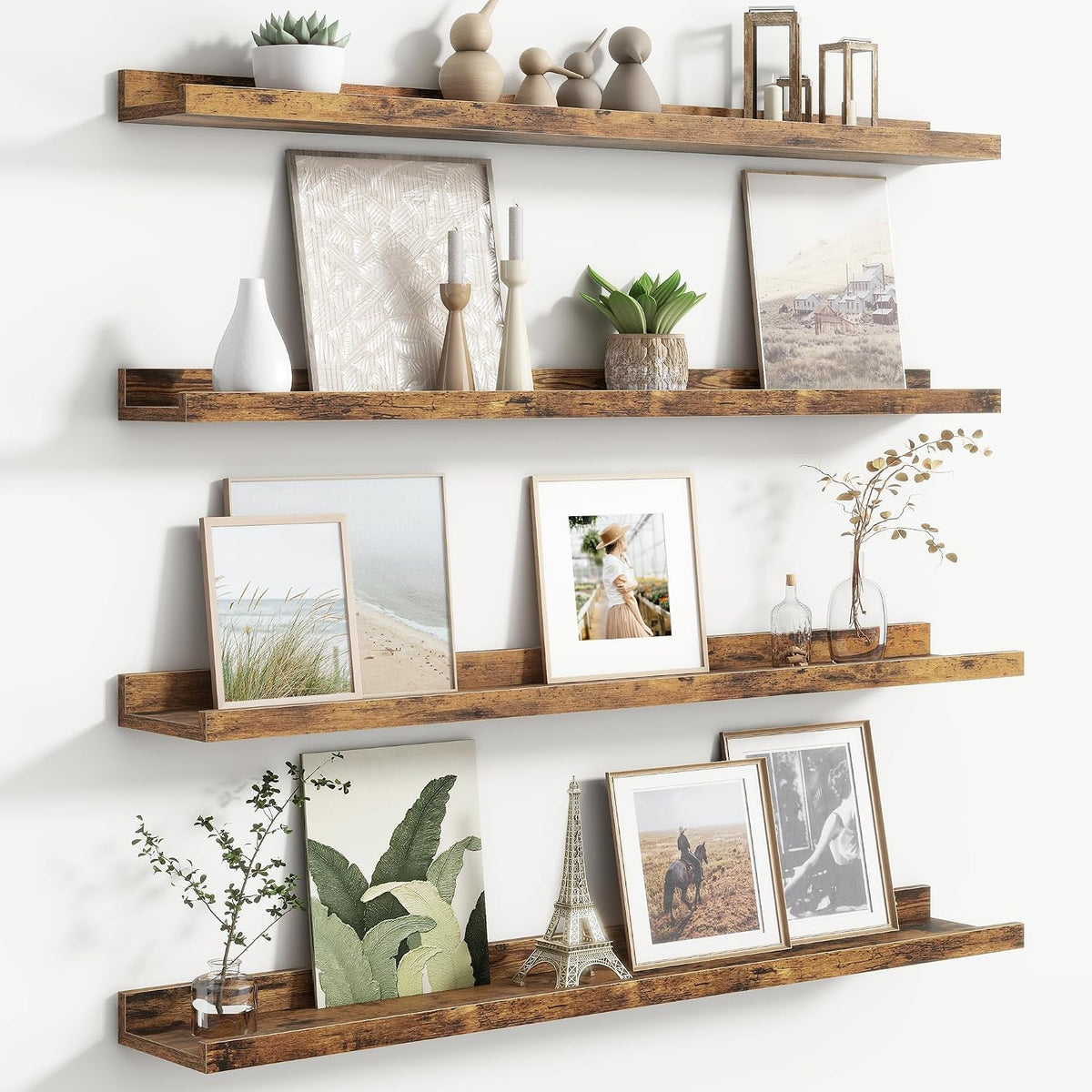 Three rustic wood picture ledges shown close-up with frames, candles, a plant and Eiffel Tower decor.