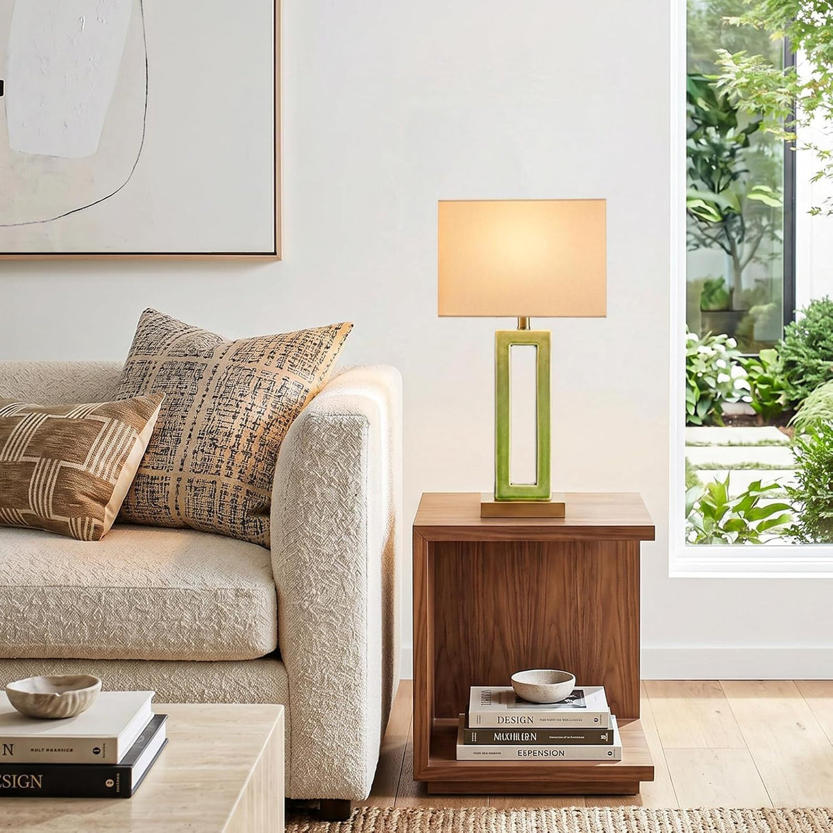 Green rectangular ceramic lamp on a small wood side table next to a textured cream sofa and window.