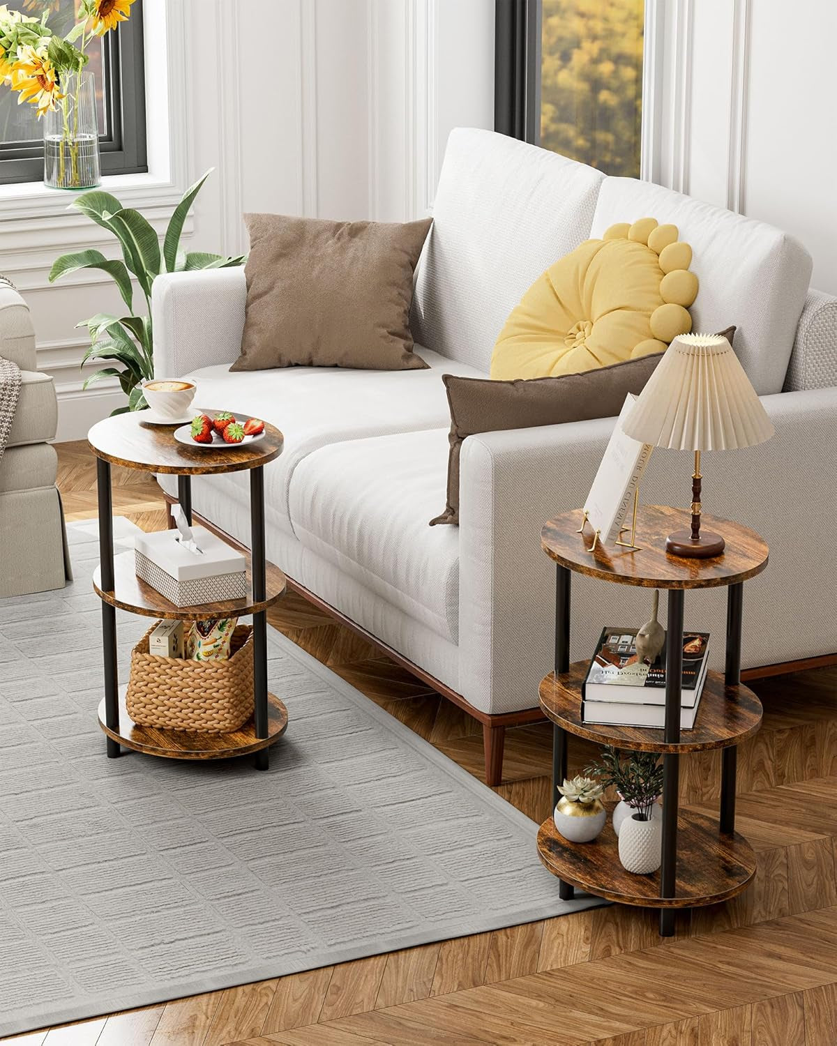 Pair of small three-tier round wood end tables beside a white sofa, styled with lamp and basket