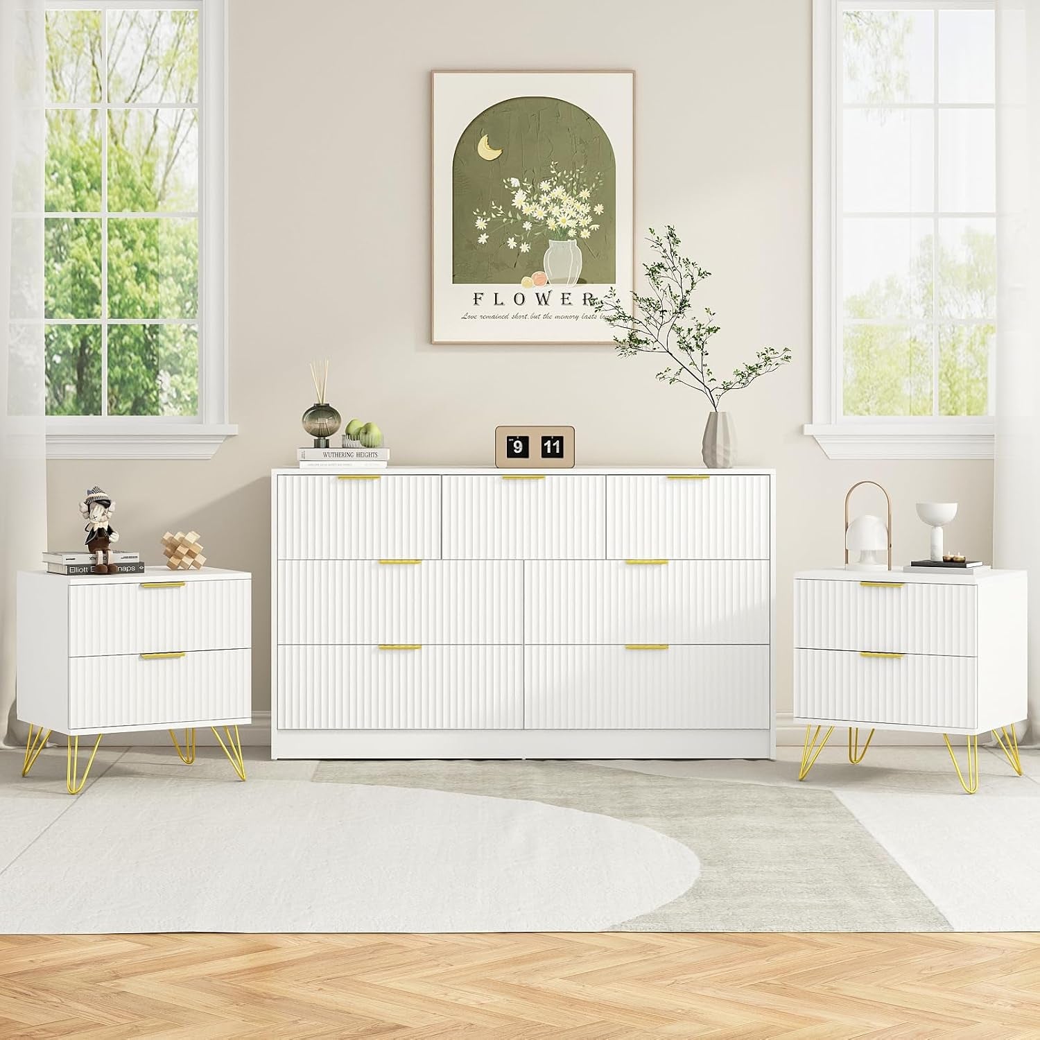 All-white seven-drawer dresser with two matching white nightstands, gold handles and hairpin legs.