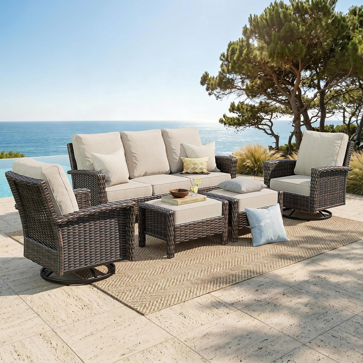 Beige-cushioned brown wicker 5-piece patio conversation set on a seaside patio, angled front view.