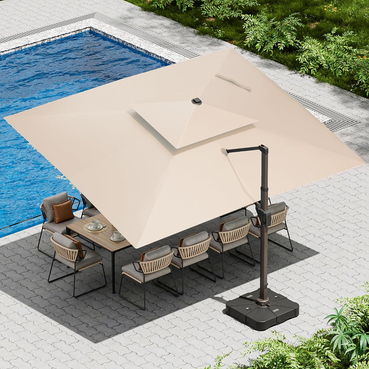 Overhead view of a beige cantilever umbrella shading a dining table beside a pool