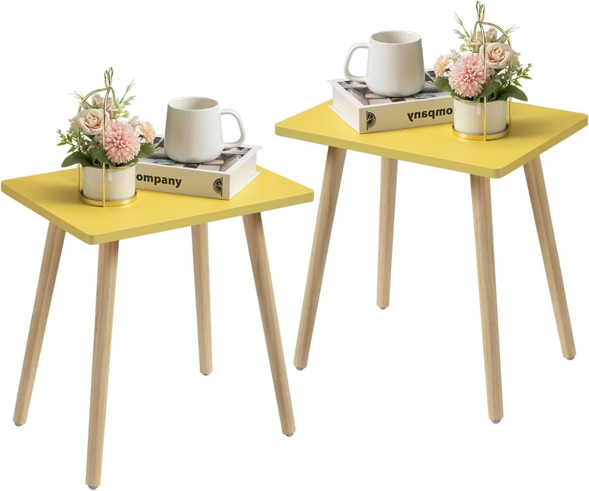 Two compact square side tables with bright yellow tops and light wood legs, each styled with a mug and small plant