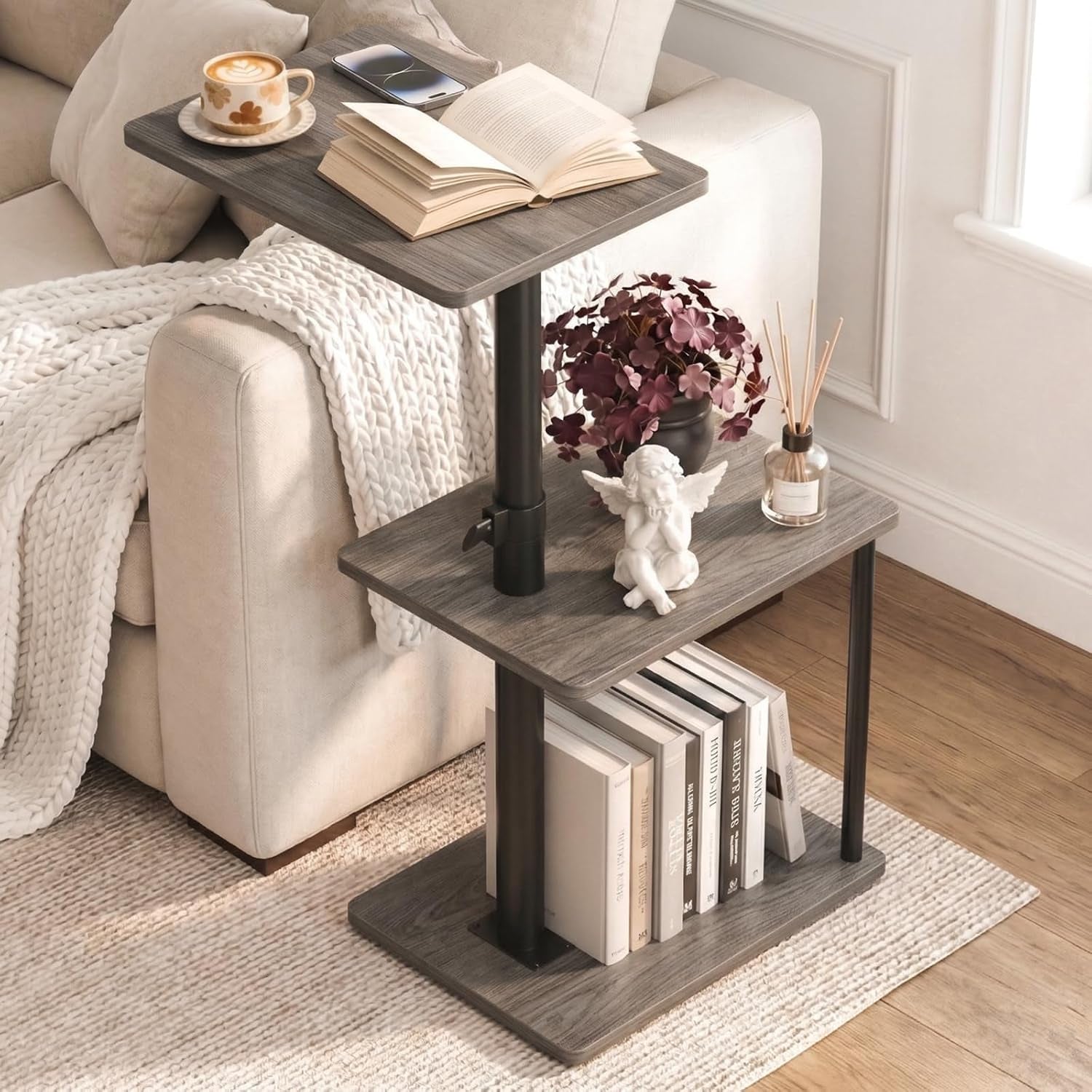 Gray-finish adjustable C-shape end table next to a sofa, showing two shelves and books below.