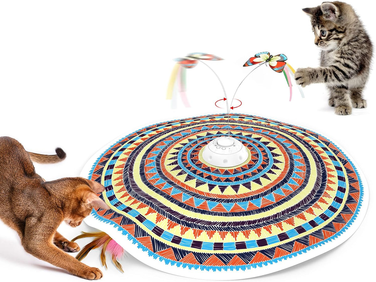 Main room shot — patterned circular play mat with spinning butterfly toy in the center and two cats interacting.