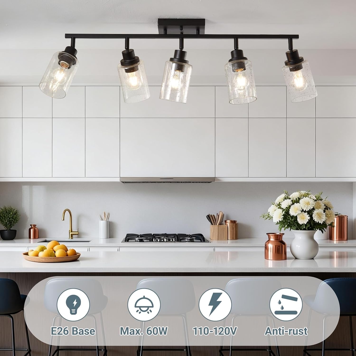 Matte black five-light track fixture mounted on the ceiling above a white kitchen counter in a staged setting
