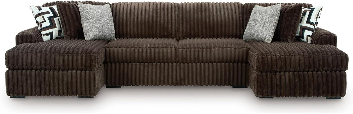 Front-facing sectional with left and right chaises in chocolate-brown corduroy and several light and patterned pillows.