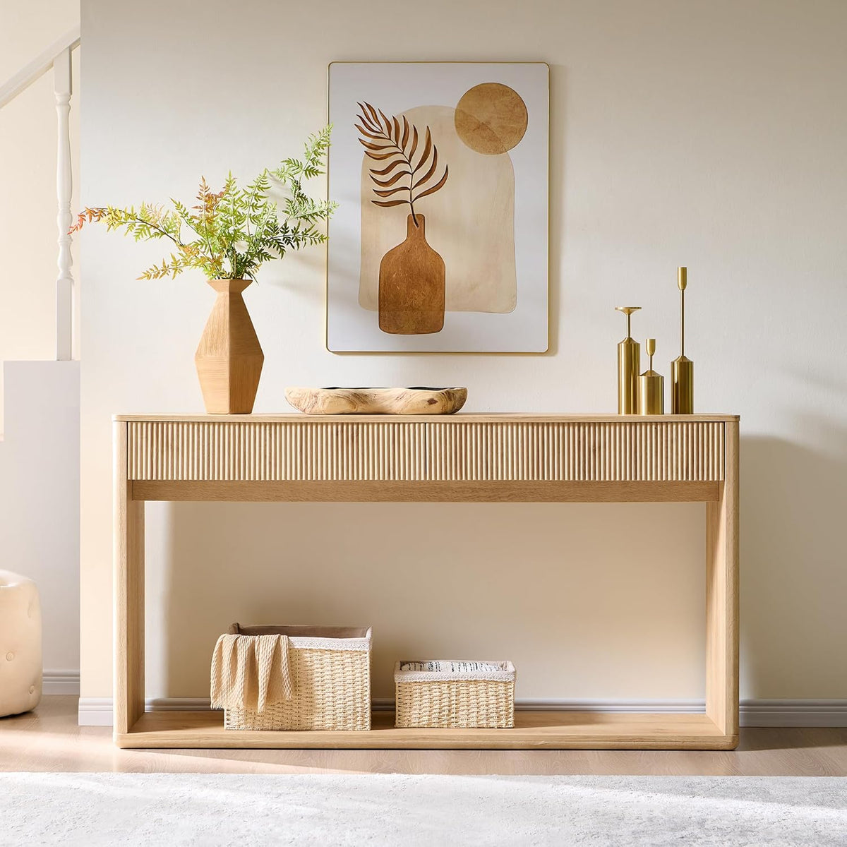 Front view of the fluted console table with decorative artwork above and baskets on the bottom shelf