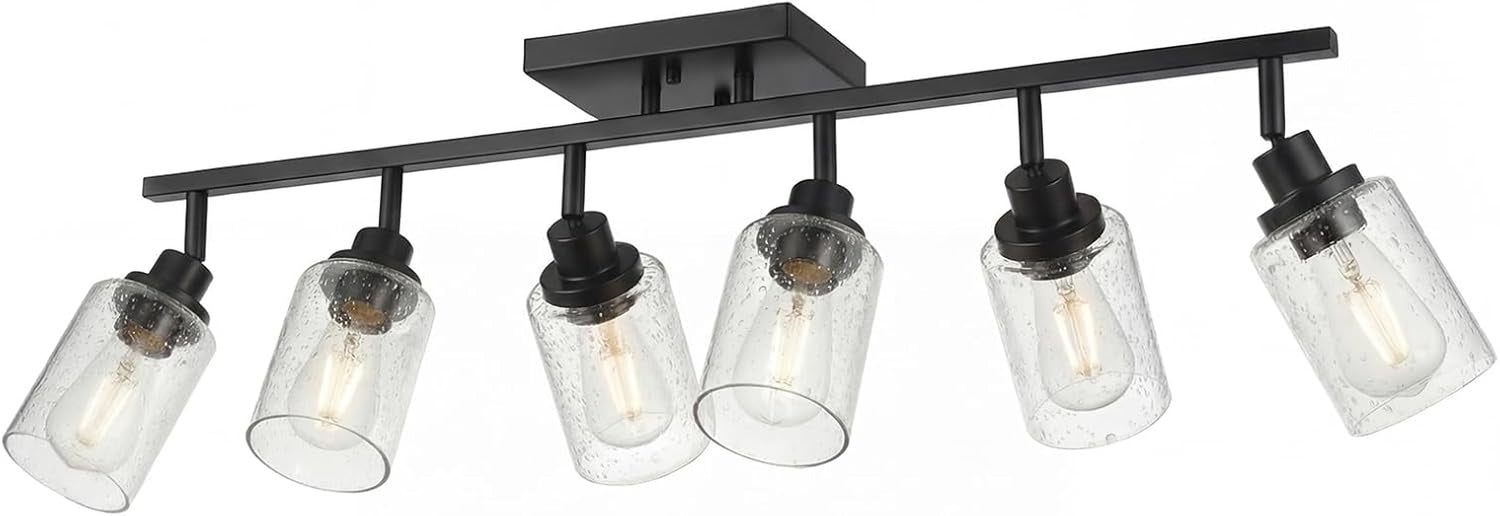 Low-angle product shot of the full five-light matte black track with seeded glass shades and visible bulbs