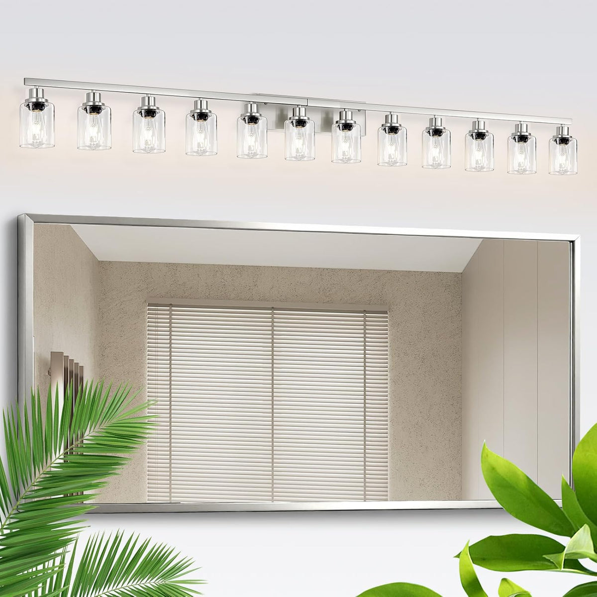 Long silver-finish vanity light with eleven clear glass shades mounted over a wide mirror