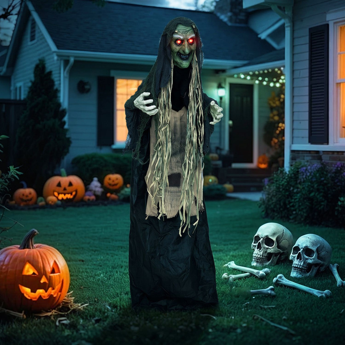 Full-length witch prop on a decorated lawn with pumpkins and skulls