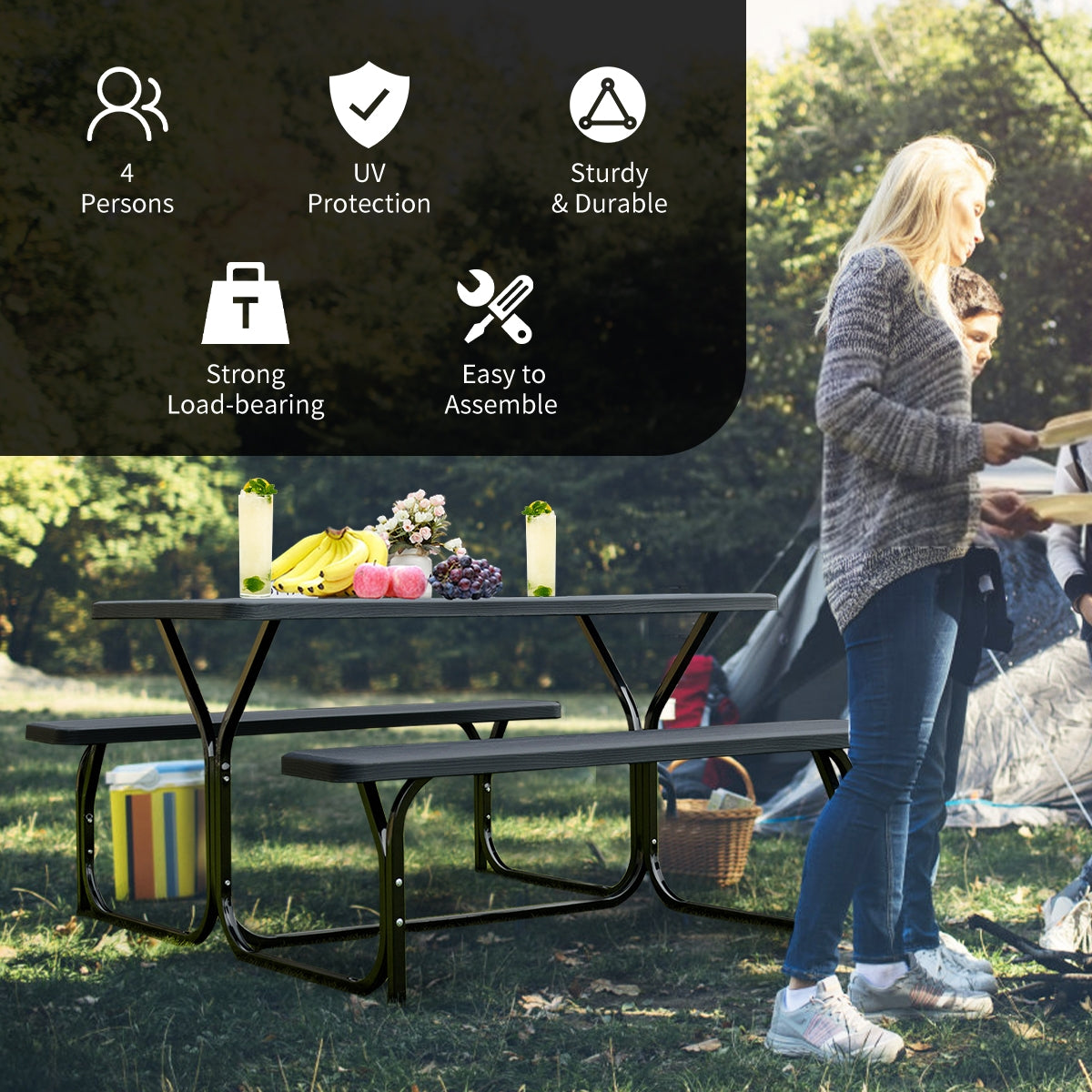 Black picnic table set outdoors with food on the tabletop as a woman and child stand nearby.