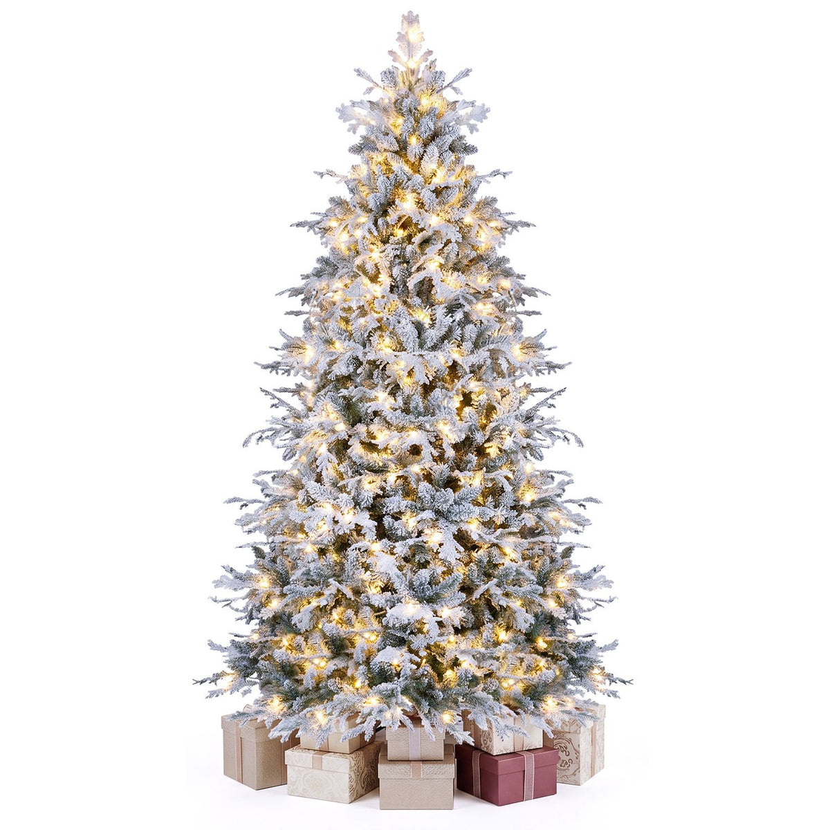 Lit, snow-flocked Christmas tree displayed against a white background with wrapped gifts around its base.