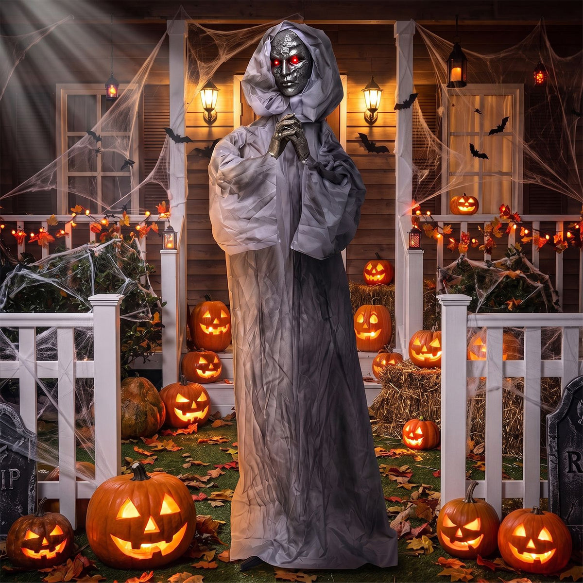 A hooded figure clasps its hands beneath a dark face with glowing red eyes, framed by pumpkins and porch cobwebs.