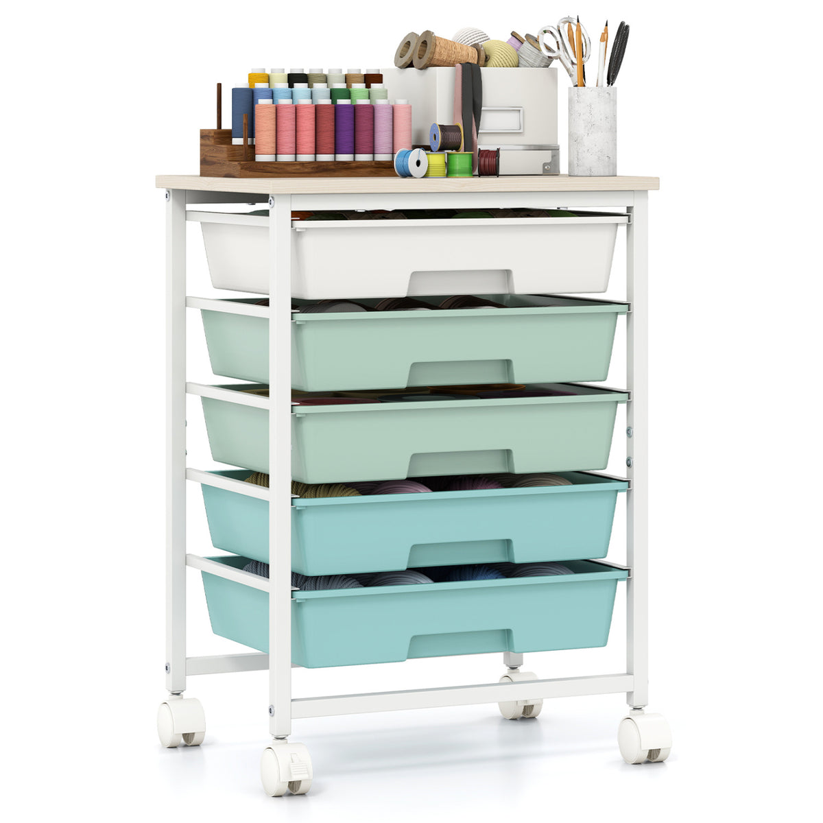 A rolling drawer cart topped with thread spools, scissors, and other sewing supplies.
