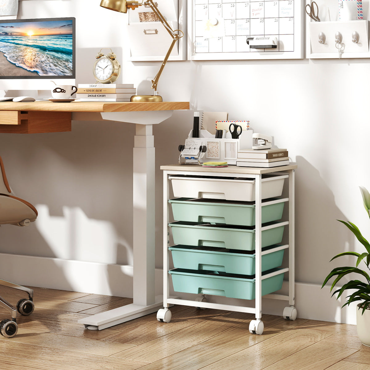A mint-green drawer cart on wheels stands beside a desk in a bright home office.