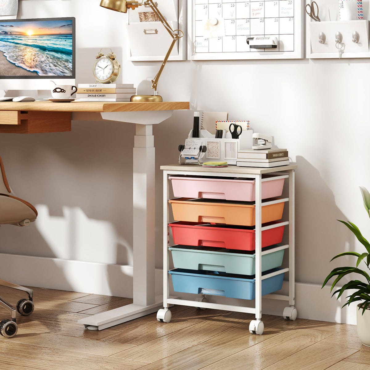 The colorful five-drawer cart sits beside a desk, with craft supplies arranged on its tabletop.