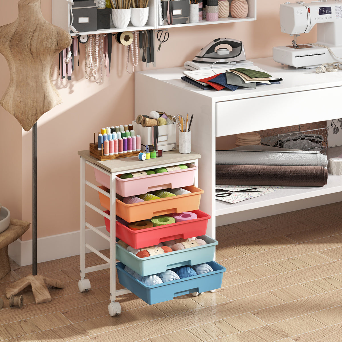A five-drawer rolling cart with a pale wood top and colorful bins in a craft room.